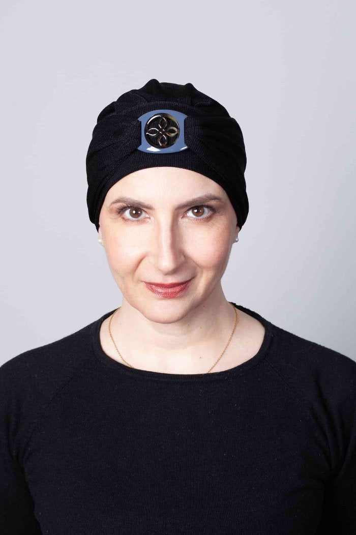 Le bonnet chimio noir à boucle laquée est en jersey pour une tenue impeccable